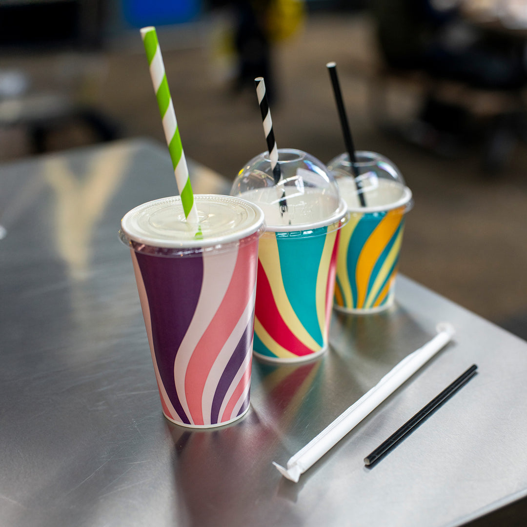 Packaging Wise patterned cold drink cups — colourful 9oz, 12oz, 16oz range displayed with straws and RPET lids for milkshakes, smoothies & cold beverages.