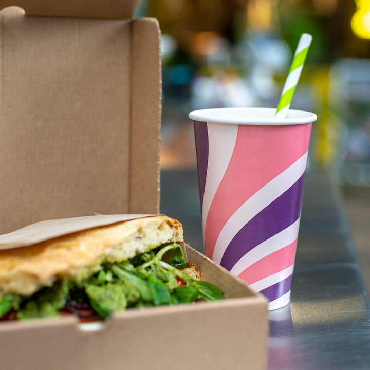 Packaging Wise 16oz patterned cold drink cup with paper straw — perfect for cafés and street food, shown next to a takeaway sandwich box.